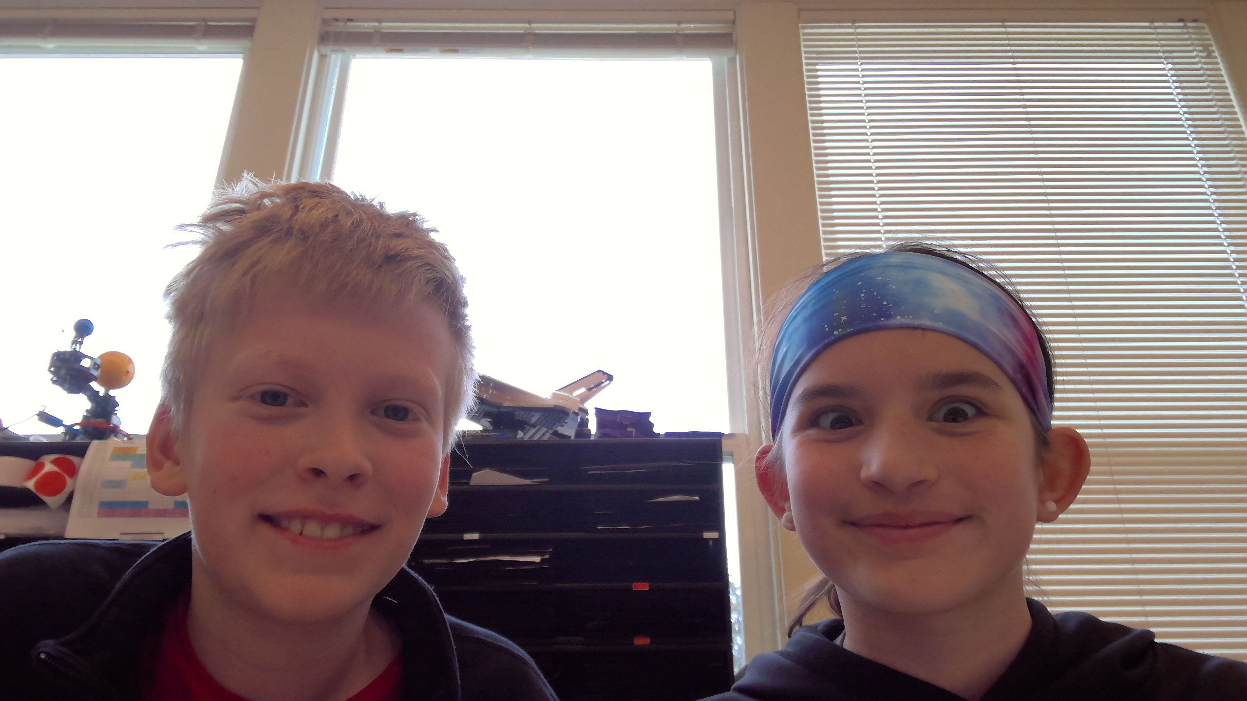 A boy and a girl smiling next to each other