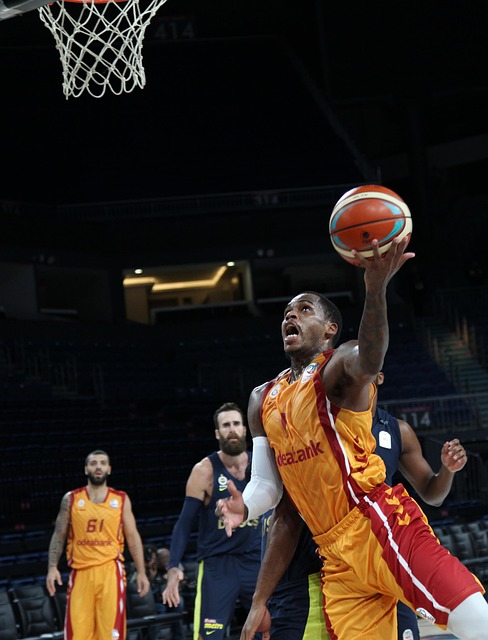basketball player trying to shoot the ball over another player