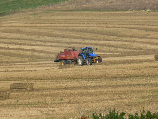 tractor pulling a haybayler