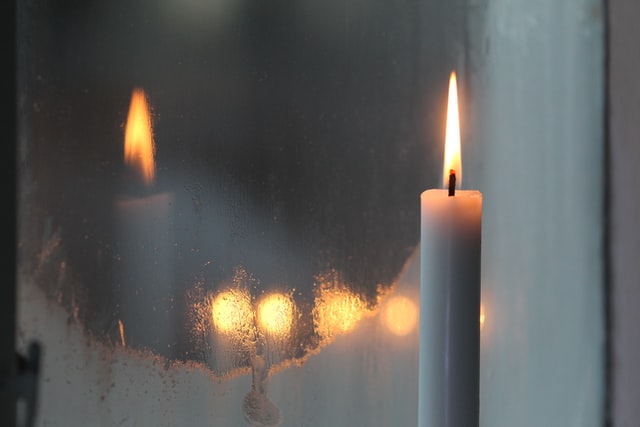 lit candle next to foggy mirror photo