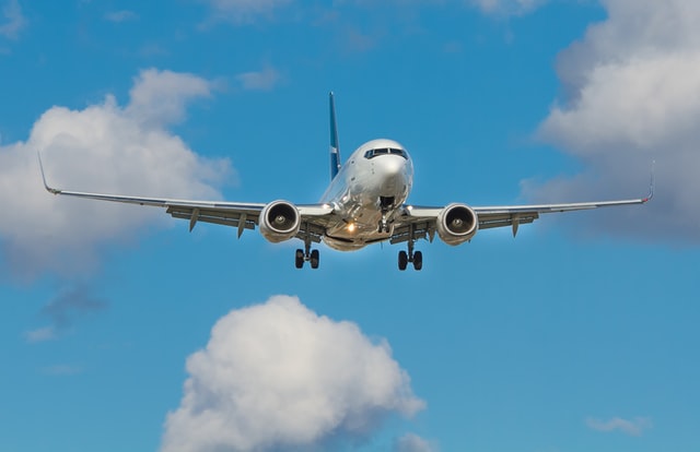 a plane fly with a baby blue sky without clouds