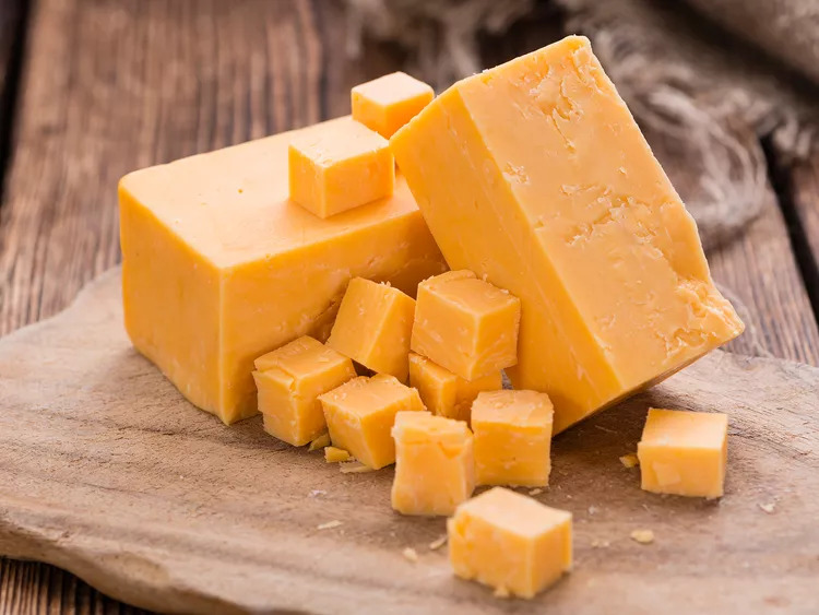 Portion of Cheddar (detailed close-up shot) on vintage wooden background iStock/Getty Images