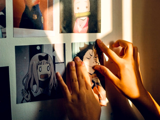 Woman putting anime pictures on her wall