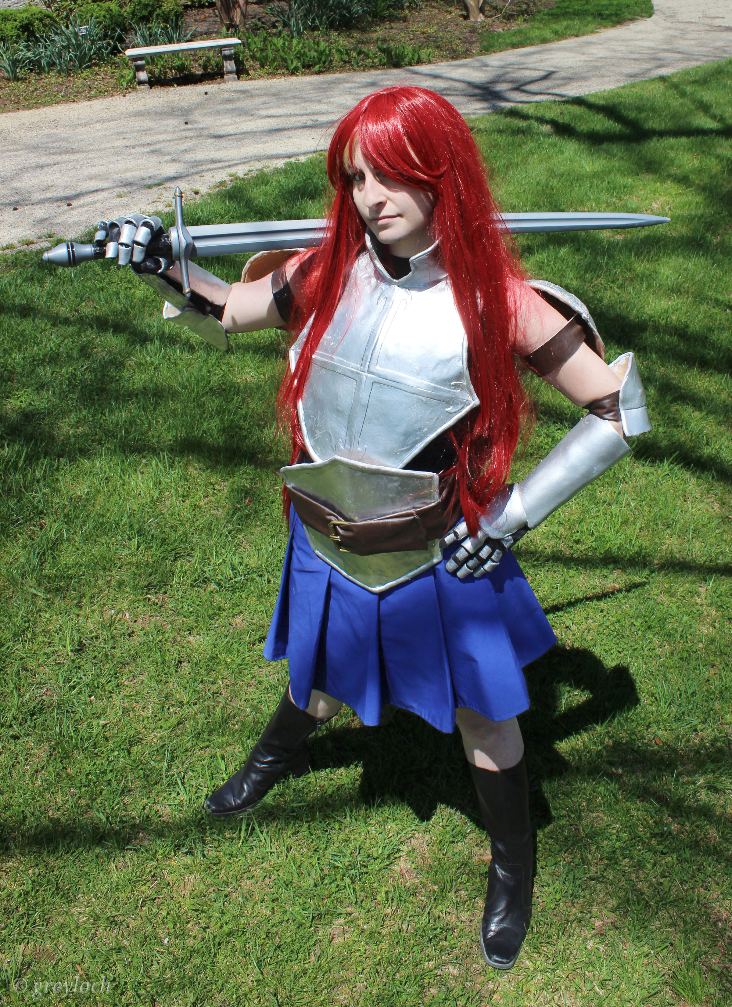 Red haired woman with sword and armour and a blue skirt withblack boots