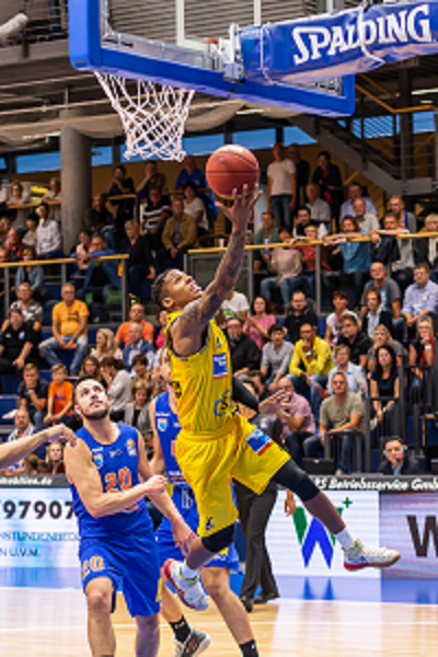 Image of a player tipping the basketball into the hoop.
