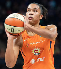 Picture of a women holding a white and orange basketball.