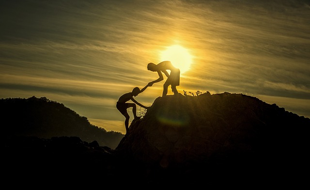 A person helping another person on a hill