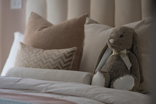 pink bed with fluffy pillows and a fuzzy stuffed rabbit